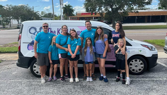 group of volunteers from Helping Hands Happy Hearts in front of a van for The Kind Mouse